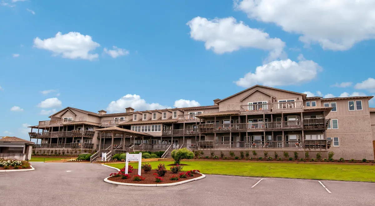 A refined view of the resort’s facade, showcasing elegant balconies and manicured gardens. The inviting atmosphere suggests opportunities for alfresco dining or peaceful strolls, seamlessly blending indoor comfort with the outdoors.